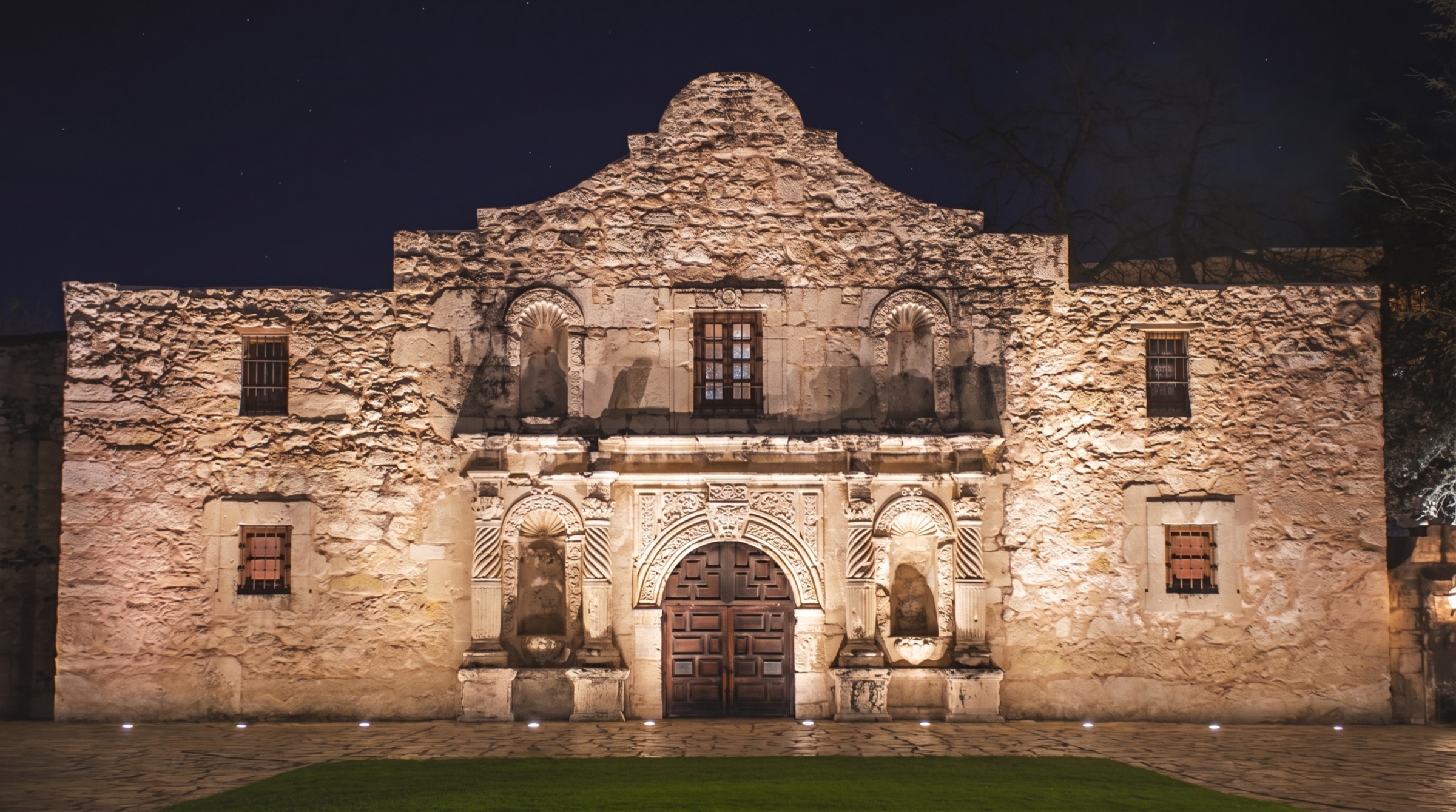 The Alamo's limestone facade floodlit at night in San Antonio