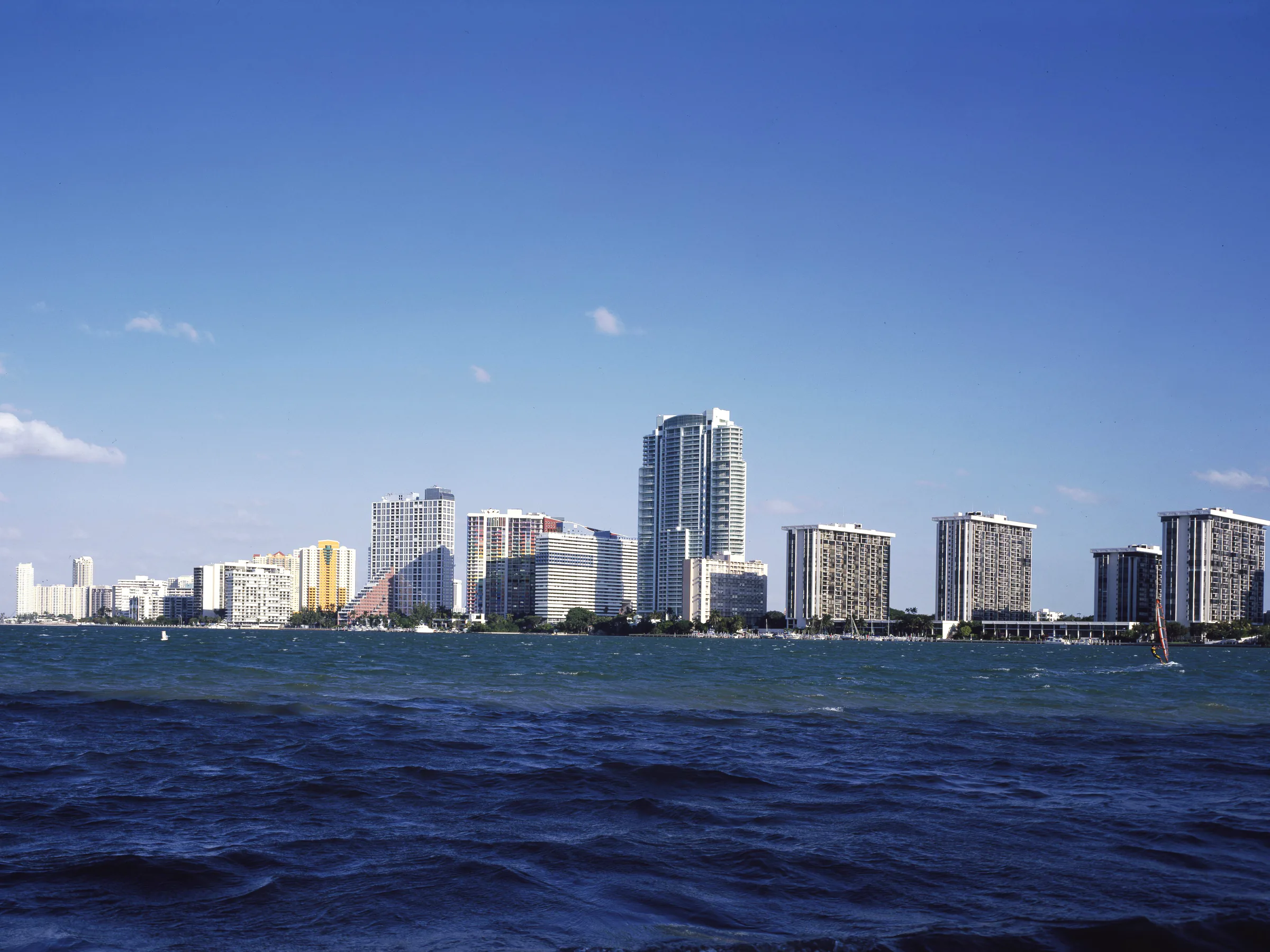 The Miami skyline across Biscayne Bay, white towers stacked along the waterfront over open water